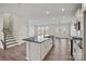 A kitchen with light wood floors, white cabinets and a large kitchen island with dark countertop at 13748 Roderick Dr # 174, Huntersville, NC 28078