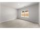 Well-lit bedroom with neutral walls, carpet flooring, and a window overlooking the outdoors at 1469 Mocksville Hwy # 21, Statesville, NC 28625