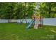 Backyard featuring a wooden playground set with swings and a slide, surrounded by green grass at 15024 Old Vermillion Dr, Huntersville, NC 28078