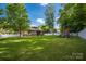 Lush backyard featuring a playground, mature trees, and partial fencing for privacy at 15024 Old Vermillion Dr, Huntersville, NC 28078