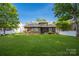Large, level backyard with lush grass, partial fencing, and a view of the home's rear exterior at 15024 Old Vermillion Dr, Huntersville, NC 28078