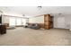 Spacious basement area with large sectional sofa, a wet bar and windows offering versatile living and entertainment space at 15024 Old Vermillion Dr, Huntersville, NC 28078