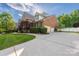 Spacious home featuring a long driveway, well-maintained lawn, and brick exterior at 15024 Old Vermillion Dr, Huntersville, NC 28078