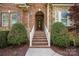 Inviting entryway with brick steps, white railings, and a beautifully decorated front door at 15024 Old Vermillion Dr, Huntersville, NC 28078