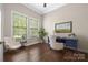 Bright office space with hardwood floors, two windows, and a stylish blue desk for a productive work environment at 15024 Old Vermillion Dr, Huntersville, NC 28078