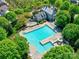 A large community pool with slide, surrounded by chairs, trees and manicured landscaping at 15323 Barnsbury Dr, Huntersville, NC 28078