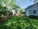 A charming backyard with green lawn, deck with stairs, and a detached garage with a separate entrance at 15323 Barnsbury Dr, Huntersville, NC 28078