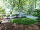 Charming backyard with well-maintained lawn, white picket fence, and detached garage amidst lush greenery at 15323 Barnsbury Dr, Huntersville, NC 28078