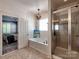 Bright bathroom featuring shiplap walls, a soaking tub, a separate shower, and a decorative pendant light at 15323 Barnsbury Dr, Huntersville, NC 28078