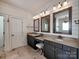 Beautiful bathroom featuring double vanities, wood-framed mirrors, and stylish lighting fixtures at 15323 Barnsbury Dr, Huntersville, NC 28078