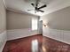 Bedroom with hardwood floors, traditional wainscotting and natural light streaming through shuttered windows at 15323 Barnsbury Dr, Huntersville, NC 28078
