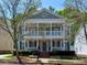 Charming two-story home with a double porch, landscaped yard, and a welcoming facade at 15323 Barnsbury Dr, Huntersville, NC 28078