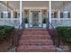 Inviting front entrance with brick steps, manicured shrubs, and charming lanterns flanking the door at 15323 Barnsbury Dr, Huntersville, NC 28078