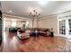 Spacious living room featuring hardwood floors, a large sectional sofa, and an open-concept layout at 15323 Barnsbury Dr, Huntersville, NC 28078