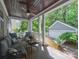 Inviting covered porch with comfortable seating, wood ceiling, and lush backyard views at 15323 Barnsbury Dr, Huntersville, NC 28078