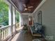 Relaxing covered porch with cozy seating, wooden ceiling, and a peaceful view at 15323 Barnsbury Dr, Huntersville, NC 28078