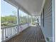 Spacious covered front porch with wood flooring, classic columns, and a serene outdoor view at 15323 Barnsbury Dr, Huntersville, NC 28078