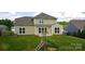 Spacious backyard featuring lush green grass, a wooden playset, and the rear exterior of the home with many windows at 15747 Reynolds Dr, Indian Land, SC 29707