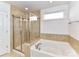 Bathroom with glass enclosed shower, soaking tub, and tiled walls at 15747 Reynolds Dr, Indian Land, SC 29707
