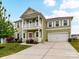 Inviting two-story home featuring a double porch, lovely landscaping, and a convenient two-car garage at 15747 Reynolds Dr, Indian Land, SC 29707