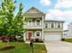 Charming two-story home with a double porch, a vibrant red door, and a well-manicured front yard at 15747 Reynolds Dr, Indian Land, SC 29707