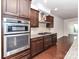 Elegant kitchen featuring stainless steel appliances and dark wood cabinets at 15747 Reynolds Dr, Indian Land, SC 29707