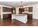 Spacious kitchen with dark wood cabinets, granite countertops, stainless steel appliances, and hardwood floors at 15747 Reynolds Dr, Indian Land, SC 29707