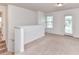 Large, open loft area with neutral carpeting, window and door to backyard at 15747 Reynolds Dr, Indian Land, SC 29707