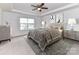 Main bedroom with a ceiling fan, tray ceiling, neutral colors, and lots of natural light at 15747 Reynolds Dr, Indian Land, SC 29707