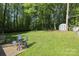 View of a large, grassy backyard with mature trees and a storage shed in the distance, perfect for outdoor activities at 1730 Deer St, Charlotte, NC 28214