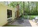 Back exterior of the home featuring a patio with seating, overlooking a lush green yard and a backdrop of mature trees at 1730 Deer St, Charlotte, NC 28214
