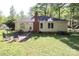 Spacious backyard with a patio set, a well-maintained lawn, and mature trees providing shade and privacy at 1730 Deer St, Charlotte, NC 28214