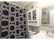 Bathroom features a black and white shower curtain, toilet, vanity with mirror and cabinet at 1730 Deer St, Charlotte, NC 28214