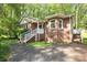 Charming brick home featuring a well-manicured lawn, complemented by lush trees and a welcoming entryway at 1730 Deer St, Charlotte, NC 28214