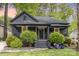 Charming front exterior showcasing a dark painted home with a welcoming front porch and manicured landscaping at 1824 Umstead St, Charlotte, NC 28205