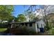 Backside view of a vintage home with white siding, an attached porch, and a covered area, nestled within trees at 2118 Polkville Rd, Shelby, NC 28150