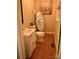 Charming half bathroom with an antique-style vanity, hardwood floors, and a decorative mirror and artwork at 212 E Stewart Ave, Mooresville, NC 28115