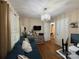 Inviting living room featuring a blue sofa, stylish chandelier, and functional workspace; ample natural light at 212 E Stewart Ave, Mooresville, NC 28115