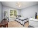 Bedroom with a ceiling fan features a bed near a window and a full-length mirror on the carpeted floor at 215 Raleigh Nw St, Concord, NC 28027