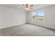 Bright bedroom featuring soft gray carpet, ceiling fan, and double windows offering neighborhood views at 221 Century Dr, Salisbury, NC 28147