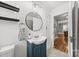 Updated bathroom featuring blue vanity, modern sink, and decorative mirror at 2222 Moose Rd, Kannapolis, NC 28083