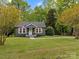Charming green home with a well-manicured lawn, American flag, and inviting front porch at 2222 Moose Rd, Kannapolis, NC 28083