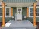 Close-up of front porch with chairs, 'Welcome' sign, wood columns, and decorative door wreath at 2222 Moose Rd, Kannapolis, NC 28083