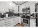 Updated kitchen features gray subway tile backsplash, granite countertops, and stainless steel appliances at 2222 Moose Rd, Kannapolis, NC 28083