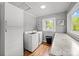 Bright laundry room featuring wood flooring, ample storage, and backyard views from the window at 2222 Moose Rd, Kannapolis, NC 28083