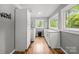 Bright laundry room featuring wood flooring, ample storage, and backyard views from the window at 2222 Moose Rd, Kannapolis, NC 28083