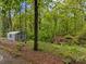 Exterior shot of a metal shed nestled among lush trees and foliage at 2222 Moose Rd, Kannapolis, NC 28083