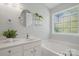 Relaxing bathroom with white cabinets, a soaking tub, and a decorative mirror at 2856 Huckleberry Hill Dr, Fort Mill, SC 29715