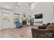Bright living room features a brick fireplace, large windows, and wood-look flooring at 2856 Huckleberry Hill Dr, Fort Mill, SC 29715