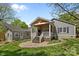 Beautiful backyard with a covered porch, stone patio, and adjacent outbuilding at 3019 Sunset Dr, Charlotte, NC 28209